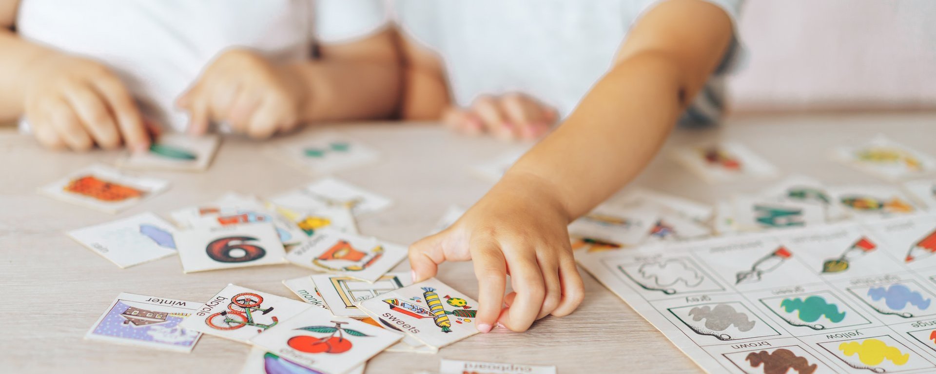 Ein Junge und Mädchen spielen Lernspiele am Schultisch.